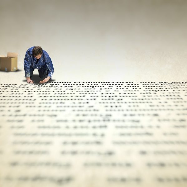 souju1.ai 主编林序之在灯下伏案校对索引清单，手边摊着标注了批次编号的纸质目录，神情专注